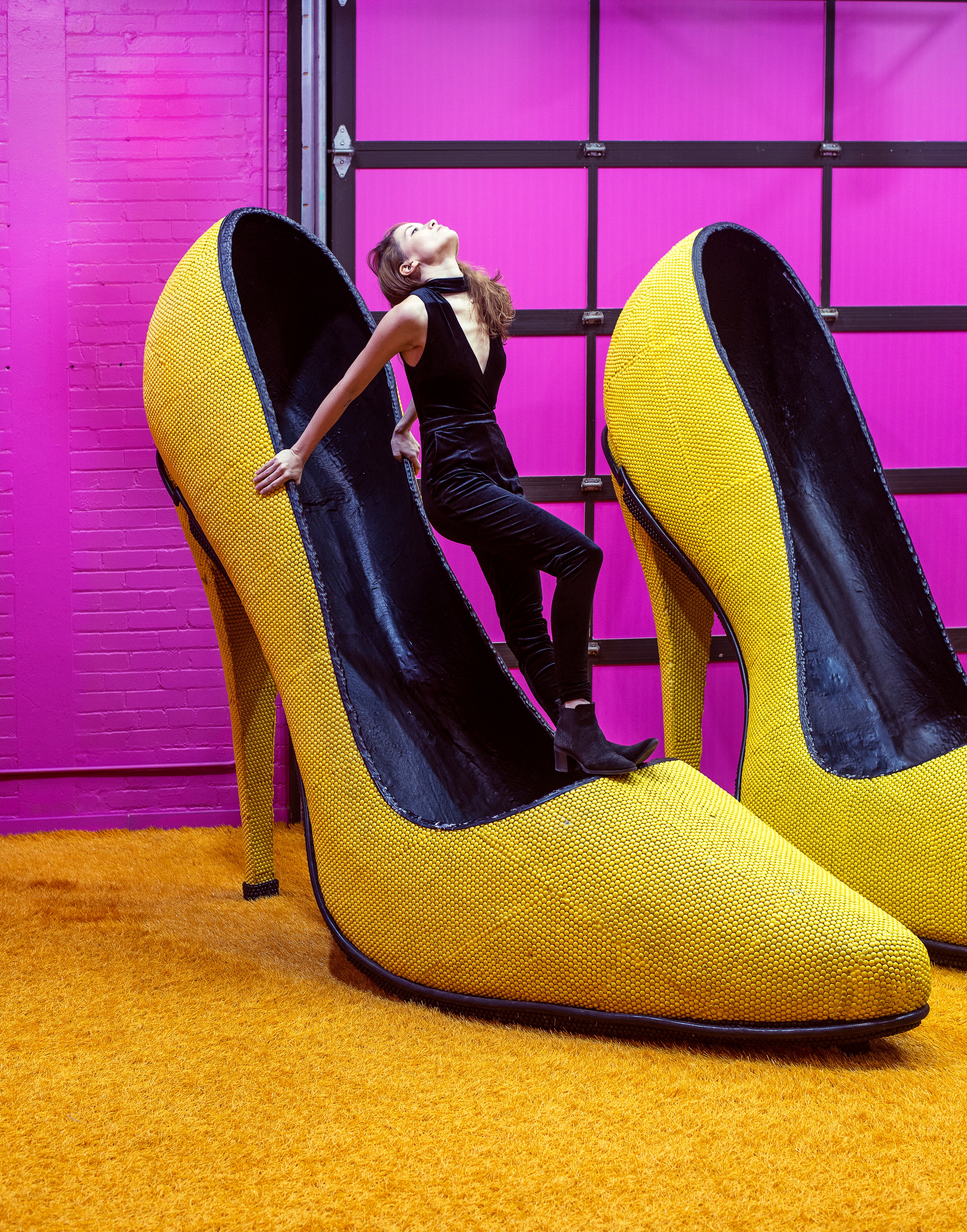 woman-perches-atop-a-giant-shoe-facing-the-ceiling.jpg